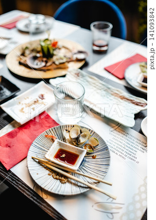 Dining table after sushi meal with leftover clams Dining table after sushi meal with leftover clams 141093842