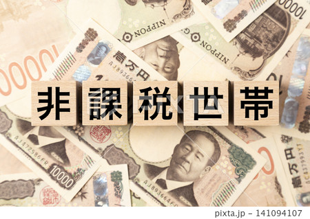 「非課税世帯」と書かれたブロックとたくさんの一万円札 「非課税世帯」と書かれたブロックとたくさんの一万円札 141094107