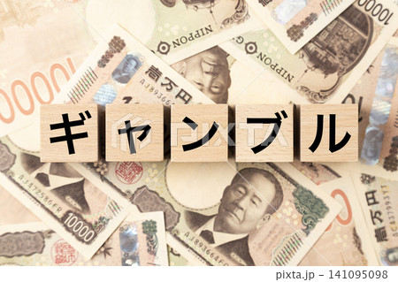 「ギャンブル」と書かれたブロックとたくさんの一万円札 「ギャンブル」と書かれたブロックとたくさんの一万円札 141095098