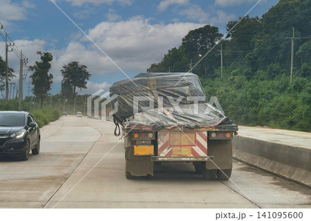 The flatbed trucks loads instability on highway. 141095600