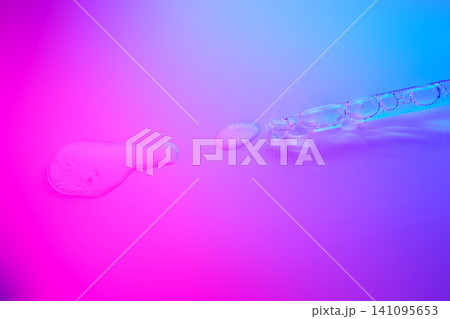 Cosmetic serum dropping on vibrant neon surface Cosmetic serum dropping on vibrant neon surface 141095653