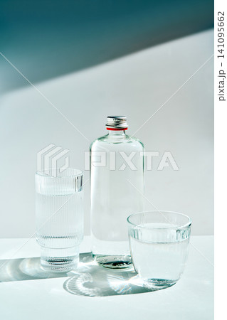 Clear glass bottle and water glasses with sunlight Clear glass bottle and water glasses with sunlight 141095662