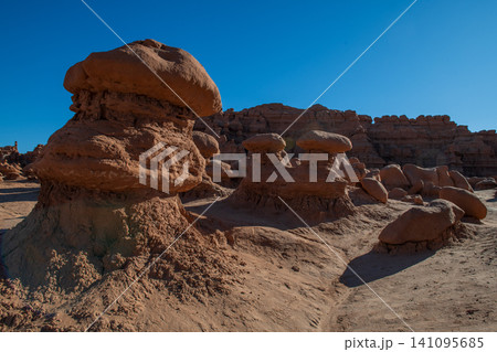 Unique eroded rock formations create majestic desert landscape under clear sky in Utah USA evoking feeling of wonder and awe. Geological marvels stand tall Unique eroded rock formations create majestic desert landscape under clear sky in Utah USA evoking feeling of wonder and awe. Geological marvels stand tall 141095685