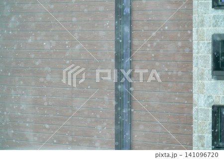 大雪が舞う住宅の木目調サイディングの外壁 大雪が舞う住宅の木目調サイディングの外壁 141096720