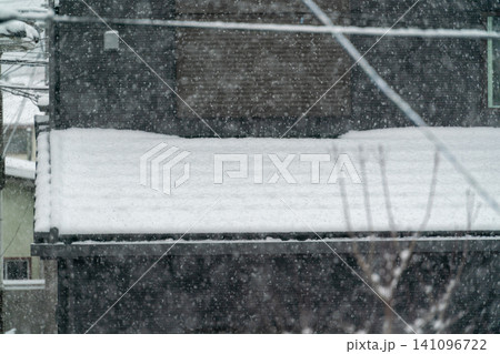 激しい大雪の中で積雪した下屋と住宅街の冬の風景 激しい大雪の中で積雪した下屋と住宅街の冬の風景 141096722