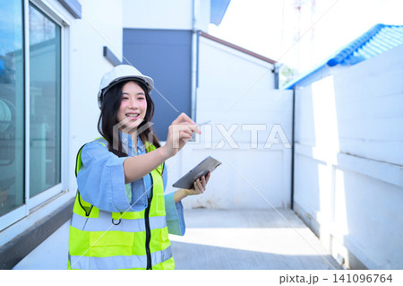 Young Asian Female Engineer Inspecting Construction Site with Tablet and Hard Hat Young Asian Female Engineer Inspecting Construction Site with Tablet and Hard Hat 141096764