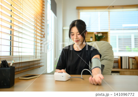 Young Asian Woman Measuring Blood Pressure at Home with Digital Sphygmomanometer Young Asian Woman Measuring Blood Pressure at Home with Digital Sphygmomanometer 141096772