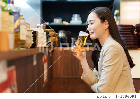 居酒屋で生ビールを飲むビジネスウーマン 居酒屋で生ビールを飲むビジネスウーマン 141096991
