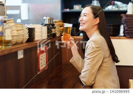 居酒屋で生ビールを飲むビジネスウーマン 居酒屋で生ビールを飲むビジネスウーマン 141096995