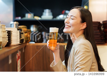 居酒屋で生ビールを飲むビジネスウーマン 居酒屋で生ビールを飲むビジネスウーマン 141096999