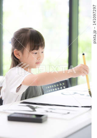 書道に集中して筆で文字を書く小学生の女の子・習字を学ぶ日本の子ども 真剣な表情 書道に集中して筆で文字を書く小学生の女の子・習字を学ぶ日本の子ども 真剣な表情 141097297