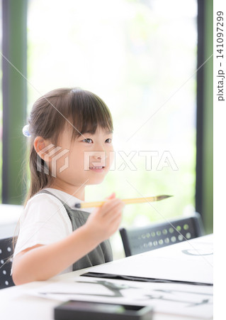 書道に集中して筆で文字を書く小学生の女の子・習字を学ぶ日本の子ども 真剣な表情 書道に集中して筆で文字を書く小学生の女の子・習字を学ぶ日本の子ども 真剣な表情 141097299
