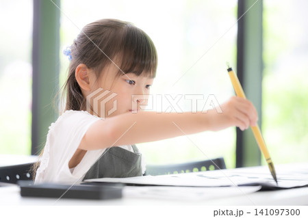 書道に集中して筆で文字を書く小学生の女の子・習字を学ぶ日本の子ども 真剣な表情 書道に集中して筆で文字を書く小学生の女の子・習字を学ぶ日本の子ども 真剣な表情 141097300