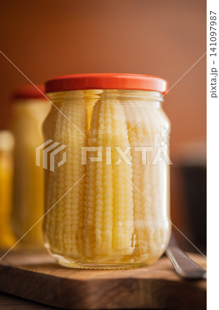 Jar of Pickled Baby Corn in Glass Jar With Red Lid on Rustic Wooden Board Jar of Pickled Baby Corn in Glass Jar With Red Lid on Rustic Wooden Board 141097987
