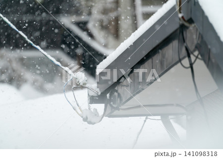 大雪で引込線に雪が積もる住宅のライフラインと冬の吹雪の風景 大雪で引込線に雪が積もる住宅のライフラインと冬の吹雪の風景 141098318