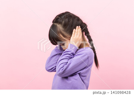 Asian little girl covering ears refusing to listen child ignoring concept Asian little girl covering ears refusing to listen child ignoring concept 141098428