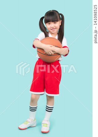 A full-body portrait of an Asian girl holding a basketball.kids sports and outdoor activity concept A full-body portrait of an Asian girl holding a basketball.kids sports and outdoor activity concept 141098525