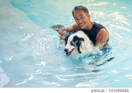 プールで犬を泳がせるシニア男性 プールで犬を泳がせるシニア男性 141098688