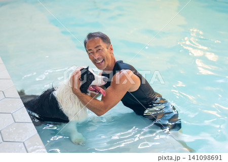 プールで犬を泳がせるシニア男性 141098691