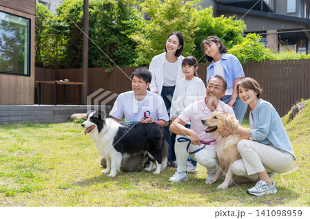 庭で犬と遊ぶ三世代家族 庭で犬と遊ぶ三世代家族 141098959