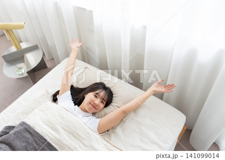 ベッドで伸びをする女性 141099014