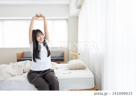 ベッドで伸びをする女性 ベッドで伸びをする女性 141099015