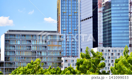 Building surrounded with green trees.  Eco-friendly building. Sustainable architecture of city reducing heat carbon dioxide modern city environment. 141099033