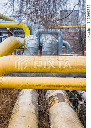 Large old pipes at the thermal station. Hot water distribution tubes from the heating system in a factory. Large old pipes at the thermal station. Hot water distribution tubes from the heating system in a factory. 141099235