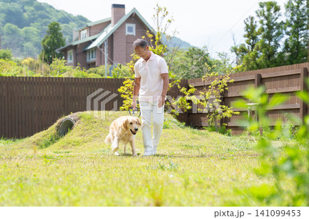 庭で愛犬と触れ合うシニア男性 141099453