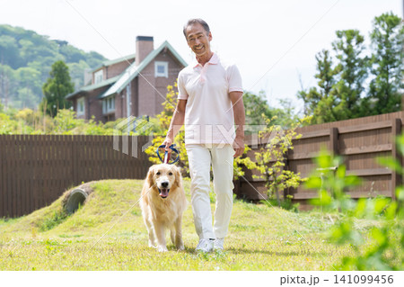 庭で愛犬と触れ合うシニア男性 庭で愛犬と触れ合うシニア男性 141099456