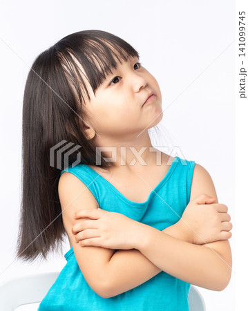 Confident little Asian girl standing with arms crossed, smiling and proud child portrait. Confident little Asian girl standing with arms crossed, smiling and proud child portrait. 141099745