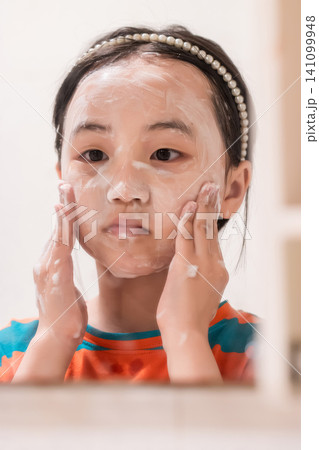 Asian little girl washing face with foam, hygiene and daily skincare routine concept 141099948
