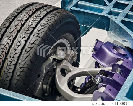 Details of a car chassis with a close view of the tire and suspension components showing construction and design choices in auto industry Details of a car chassis with a close view of the tire and suspension components showing construction and design choices in auto industry 141100090