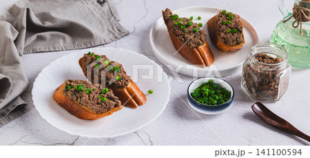 Delicious sandwiches with pork liver pate and green onions on a plate on the table web banner 141100594