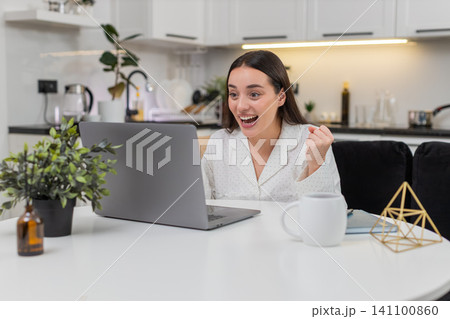 Young woman celebrates discount success promo code works smiles big happy reaction online shopping Young woman celebrates discount success promo code works smiles big happy reaction online shopping 141100860
