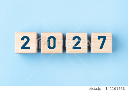 Wooden cubes with numbers of the New Year 2027 on a blue background Wooden cubes with numbers of the New Year 2027 on a blue background 141101268