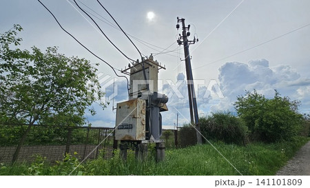 Rural electrical transformer substation and power distribution lines supplying energy to countryside community. essential public utilities. Rural electrical transformer substation and power distribution lines supplying energy to countryside community. essential public utilities. 141101809