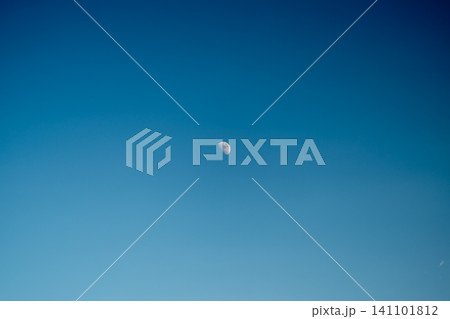 Small crescent moon high in clear blue sky with subtle color gradient Small crescent moon high in clear blue sky with subtle color gradient 141101812