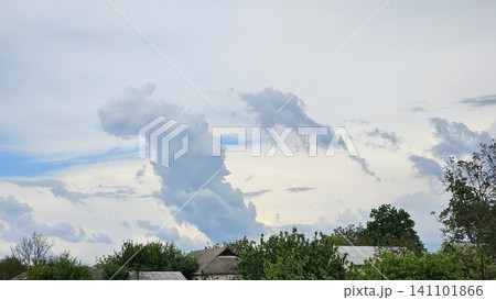 Spectacular volumetric clouds above rural houses creating dramatic and dreamlike countryside sky landscape 141101866