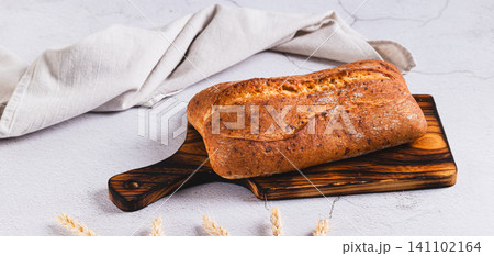 Fresh baked ciabatta loaf bread on a cutting board on the table web banner Fresh baked ciabatta loaf bread on a cutting board on the table web banner 141102164