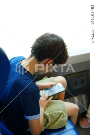 Child Engaged with Tablet While Traveling on Train Child Engaged with Tablet While Traveling on Train 141102492