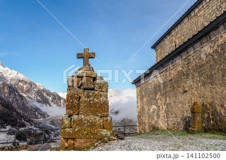 Ancient stone cross monument near an old medieval Christian church in the Caucasus mountains 141102500
