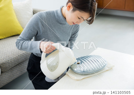 湯たんぽを使う女性 湯たんぽを使う女性 141103505