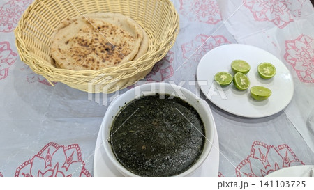 Molokhia and shrimp soup with cut limes and a basket of flatbread Molokhia and shrimp soup with cut limes and a basket of flatbread 141103725