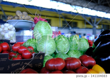 Fresh cabbage displayed at local market with eggplants tomatoes mushrooms and potatoes colorful farm vegetables and healthy seasonal produce 141104083