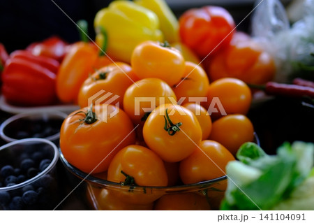 yellow tomatoes at the market. Fresh yellow tomatoes in a clear glass bowl 141104091