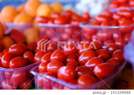 red cherry tomatoes at market. vibrant cluster of ripe, red cherry tomatoes 141104098