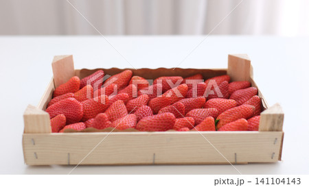 strawberries in a wooden box ripe juicy strawberries, harvest in a basket on the table strawberries in a wooden box ripe juicy strawberries, harvest in a basket on the table 141104143