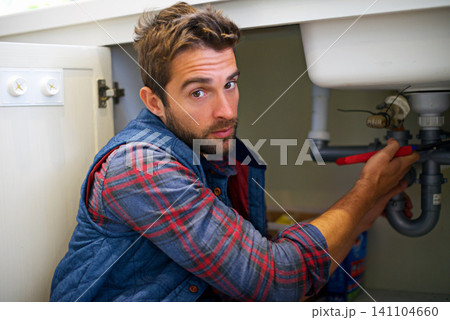 Man, portrait and plumbing with wrench for pipe repair, service or fix in home maintenance or indoor leak. Male person, plumber or handyman smile with water damage or sink with professional at house Man, portrait and plumbing with wrench for pipe repair, service or fix in home maintenance or indoor leak. Male person, plumber or handyman smile with water damage or sink with professional at house 141104660