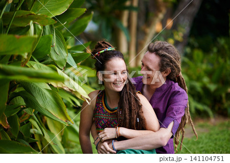 Nature, hipster and couple hugging in garden on outdoor romantic date together for bonding. Smile, love and happy rasta young man and woman laughing and embracing with care in park or field. Nature, hipster and couple hugging in garden on outdoor romantic date together for bonding. Smile, love and happy rasta young man and woman laughing and embracing with care in park or field. 141104751